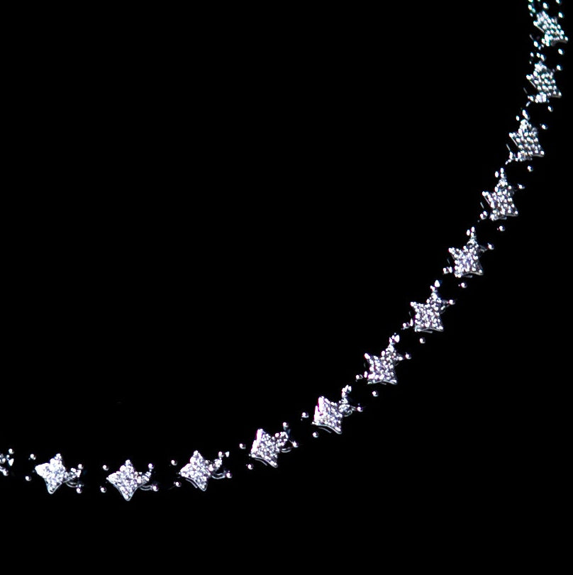 A silver-toned star-link chain necklace displayed on a black jewelry bust against a dark gray background.